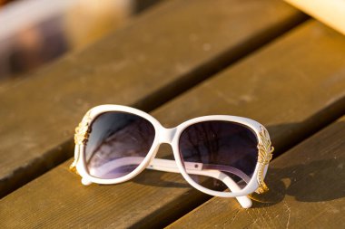 Güneş gözlüklü beyaz model özel tasarım çekimleri olan kadınlar için bir yaz günü dışarıda. Seçici odak 