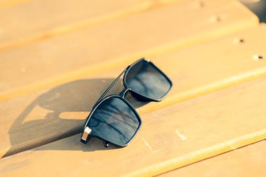 Büyük siyah lensli büyük ölçekli güneş gözlüğü mankeni bir yaz günü yakın planda doğada çekim yapıyor. Seçici odak