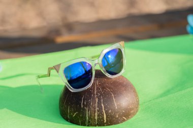 Bir yaz günü güneşi yansıtan mavi lensli fütüristik güneş gözlüklü özel model açık havada çekim yapıyor. Seçici odak