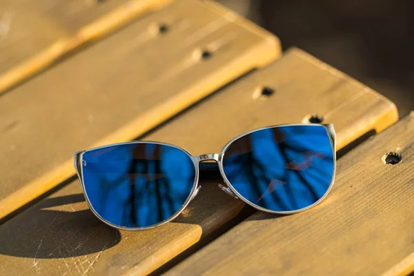 Fashion cat eye sunglasses model for women with big blue lenses shoot outside in a summer day closeup. Selective focus