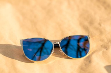 Büyük mavi lensli kadınlar için moda kedi gözü güneş gözlüğü modeli güneşli bir günde dışarıda çekim yapıyor. Seçici odak 