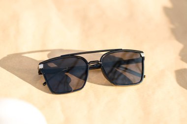 Büyük siyah lensli büyük ölçekli güneş gözlüğü modeli güneşli bir günde açık havada çekim yapıyor. Seçici odak