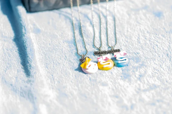 Drie gekleurde hangers beste vrienden ketting schieten buiten in een zomerse dag close-up. Selectieve focus — Stockfoto