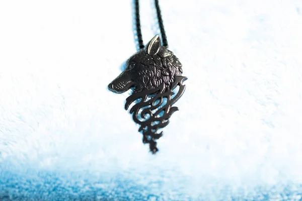 Pendant wolf head necklace black color shoot outside in a sunny day closeup. Selective Focus