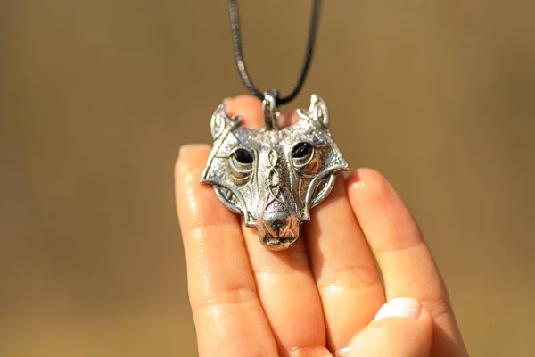 Pendant wolf head necklace silver color stainless steel shoot outside in a summer day closeup. Selective Focus — Stock Photo, Image