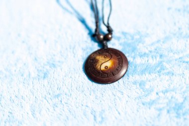 Yin Yang kolye kahverengi renkli kolye güneşli bir günde dışarıda çekiliyor. Seçici Odaklanma