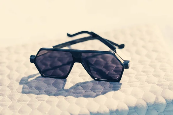 Modelo de gafas de sol futuristas de gran tamaño con lentes negras y montura negra para disparar al aire libre en un primer plano de día soleado. Enfoque selectivo —  Fotos de Stock