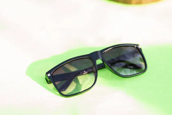 Design de óculos de sol clássicos para homens e senhoras com lentes pretas e moldura preta atirar fora em um dia de verão closeup. Foco seletivo — Fotografia de Stock