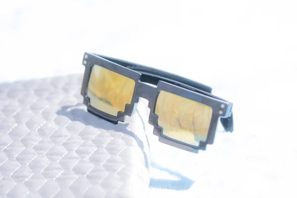 Золотые линзы с 8-битным дизайном солнцезащитных очков снимают в летний день. Селективный фокус — стоковое фото