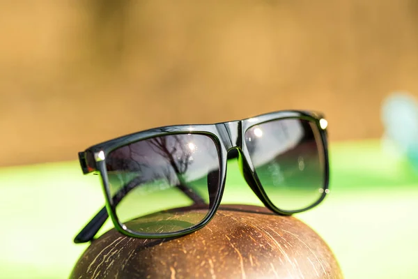 Diseño de gafas de sol clásicas para hombres y mujeres con lentes negras y montura negra en el exterior en un primer plano de día de verano. Enfoque selectivo — Foto de Stock