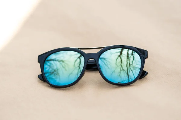 El diseño de gafas de sol de moda con lentes azules dispara afuera en un primer plano de día de verano. Enfoque selectivo —  Fotos de Stock