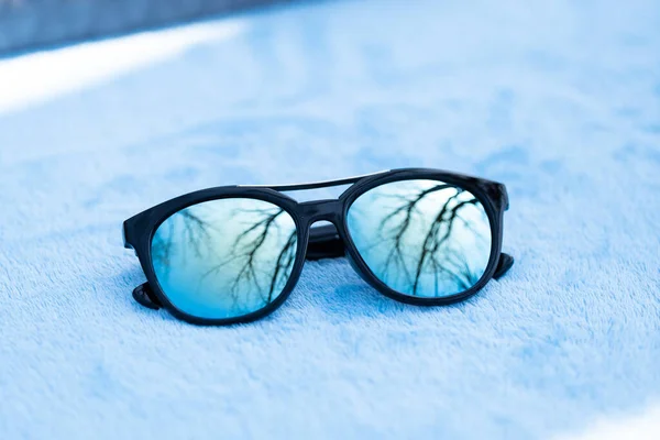 El diseño de gafas de sol de moda con lentes azules dispara afuera en un primer plano de día de verano. Enfoque selectivo —  Fotos de Stock