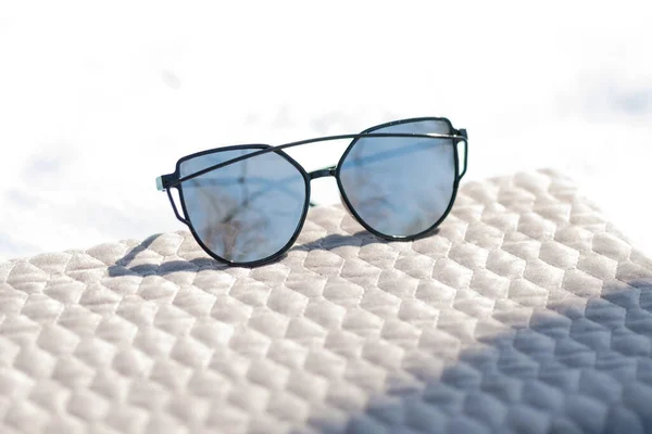Сонцезахисні окуляри Cat eye спеціальної моделі зі срібними лінзами та чорною рамкою в літній день крупним планом. Вибірковий фокус — стокове фото
