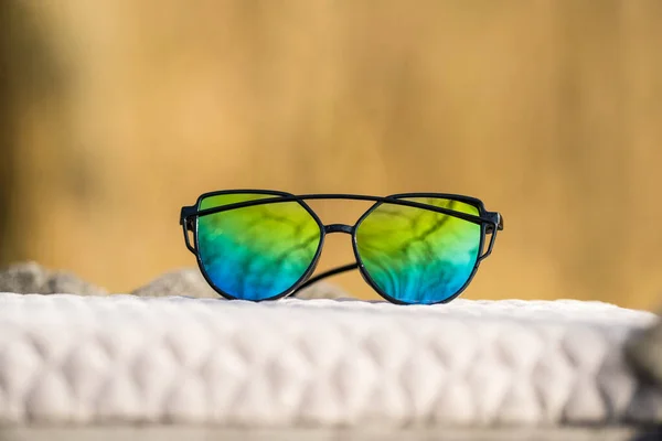 Kočičí oko sluneční brýle speciální model s barevnými čočkami a černý rám střílet v slunečný den detailní záběr. Selektivní zaměření — Stock fotografie