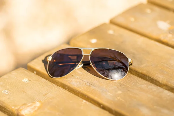 Model okularów przeciwsłonecznych Aviator z dużymi brązowymi soczewkami kręci się na zewnątrz w letni dzień zbliżenia. Skupienie selektywne — Zdjęcie stockowe