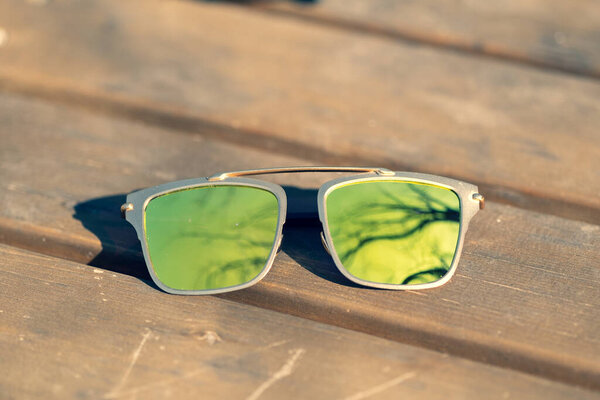 Futuristic sunglasses design with big green lenses closeup shoot outside in a summer day . Selective focus