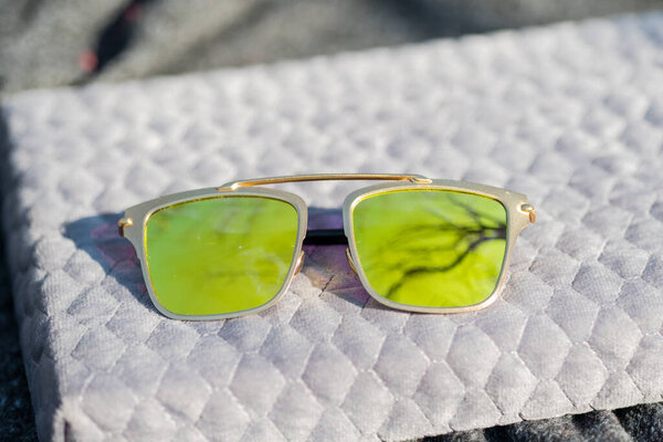 Futuristic sunglasses design with big green lenses closeup shoot outside in a summer day . Selective focus