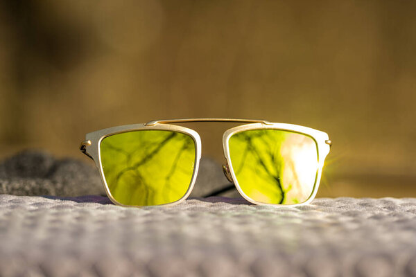 Futuristic sunglasses design with big green lenses closeup shoot outside in a summer day . Selective focus