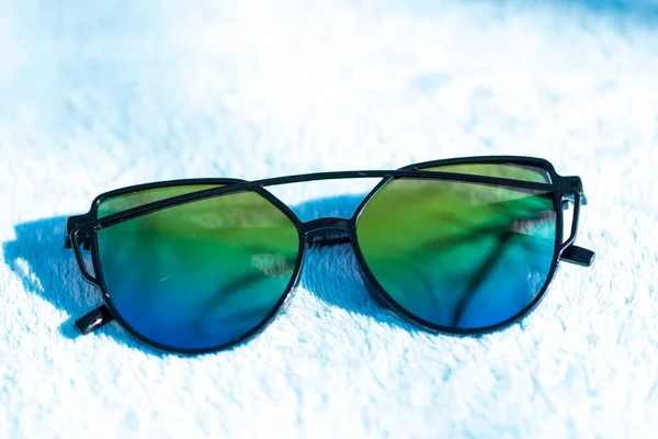 Сонцезахисні окуляри Cat eye спеціальної моделі з кольоровими лінзами та чорною рамкою в сонячний день крупним планом. Вибірковий фокус — стокове фото