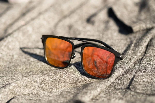 Futuristic sunglasses design with big red flat lenses closeup shoot outside in a summer day . Selective focus — Stock Photo, Image