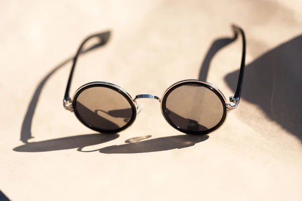 Класичний дизайн сонцезахисних окулярів зі срібними круглими лінзами знімається в сонячний день літа крупним планом. Вибірковий фокус — стокове фото