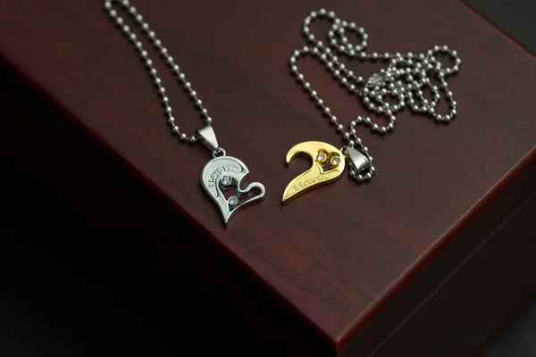 Paar Set Anhänger Halskette die Hälfte des Herzens Gold und Splitter Farbe schießen Nahaufnahme. Selektiver Fokus — Stockfoto