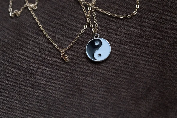Yin Yang pendant necklace handmade black and white closeup. Selective Focus