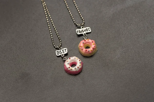 Hanger set van beste vrienden twee donuts ketting closeup. Selectieve focus — Stockfoto