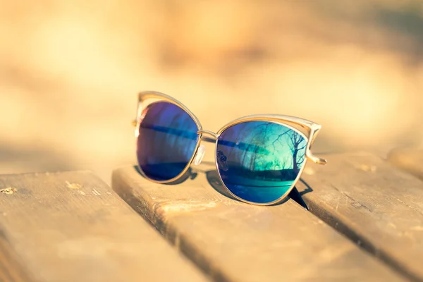 Modelo de gafas de sol de ojo de gato de moda para damas con lentes azules y montura dorada disparan afuera en un primer plano de día soleado. Enfoque selectivo — Foto de Stock