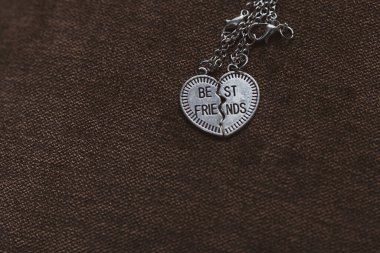 Pendant of best friends heart in two parts necklace closeup. Selective Focus clipart