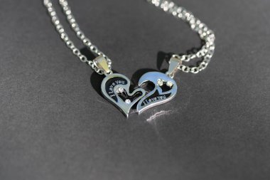 Çift, güneşli bir günde kalbin iki yarısı kadar kolye takıyor. Seçici odak