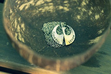 Çift, güneşli bir günde kalbin iki yarısı kadar kolye takıyor. Seçici odak