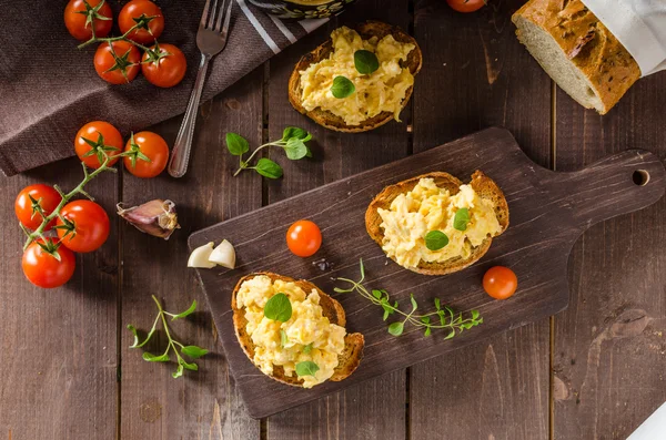 Huevos revueltos con hierbas y ajo sobre pan tostado —  Fotos de Stock