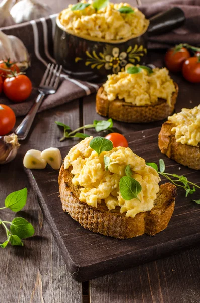Huevos revueltos con hierbas y ajo sobre pan tostado —  Fotos de Stock