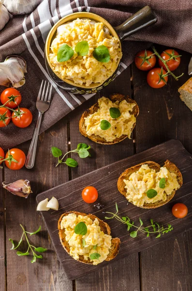 Scrambled eggs with herbs and garlic on toasted bread — Stock Photo, Image