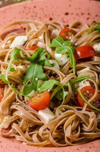 Espaguetis con mozzarella, tomates cherry y rúcula — Foto de Stock