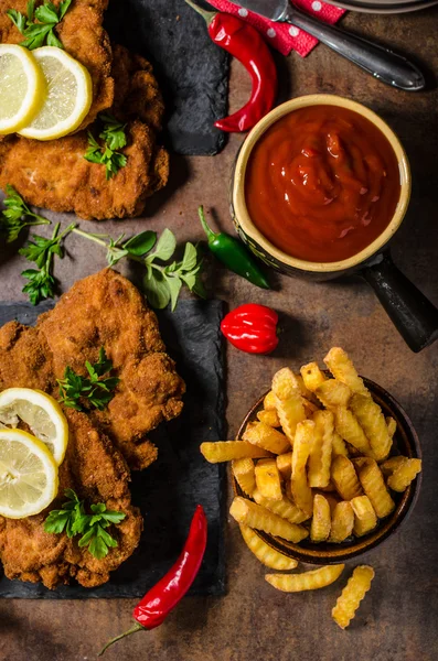 Schnitzel with fries, salad and herbs — Stock Photo, Image