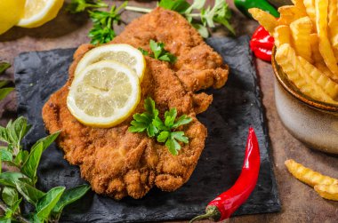 Şnitzel ile patates kızartması, salata ve otlar