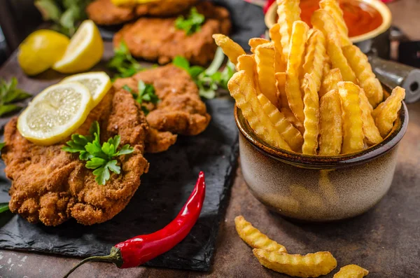 Schnitzel with fries, salad and herbs — Stock Photo, Image