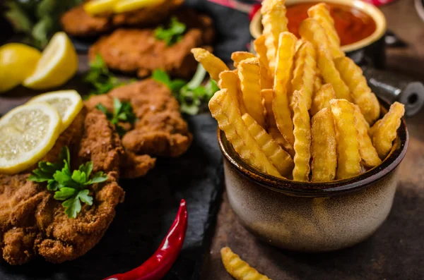 Schnitzel with fries, salad and herbs — Stock Photo, Image