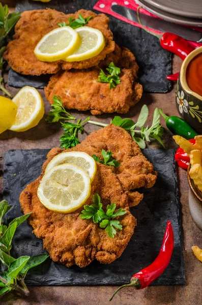 Schnitzel with fries, salad and herbs — Stock Photo, Image