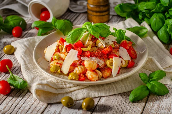 Lezzetli ve sade yemek, domates soslu ev yapımı gnocchi, parmesan, zeytin ve fesleğen.