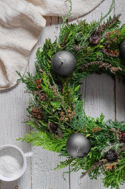 Noel tatili için ev yapımı ahşap evlerle doğal çelenk.