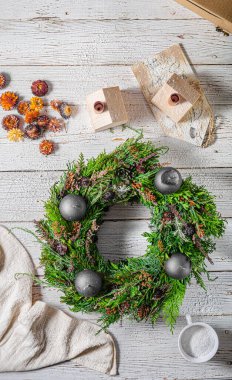 Noel tatili için ev yapımı ahşap evlerle doğal çelenk.