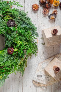 Noel tatili için ev yapımı ahşap evlerle doğal çelenk.