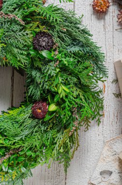 Noel tatili için ev yapımı ahşap evlerle doğal çelenk.