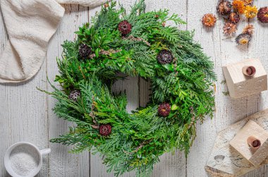 Noel tatili için ev yapımı ahşap evlerle doğal çelenk.