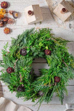 Noel tatili için ev yapımı ahşap evlerle doğal çelenk.