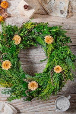 Noel tatili için ev yapımı ahşap evlerle doğal çelenk.