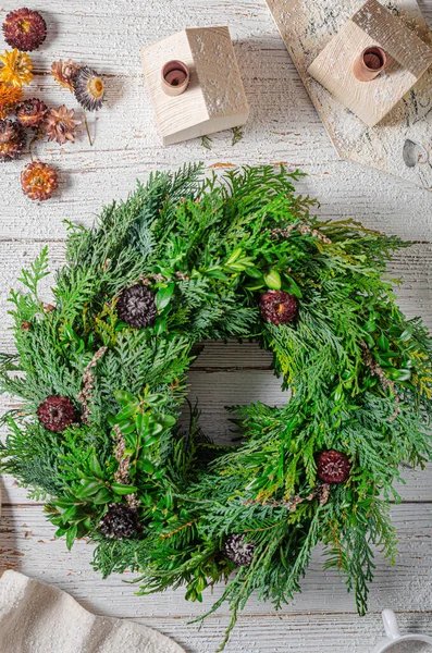 Noel tatili için ev yapımı ahşap evlerle doğal çelenk.